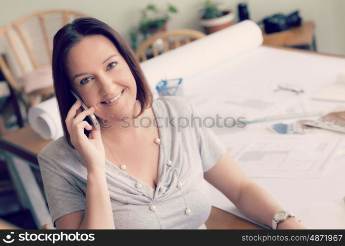 Woman talking over phone in office