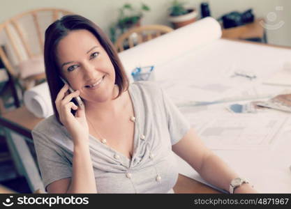 Woman talking over phone in office