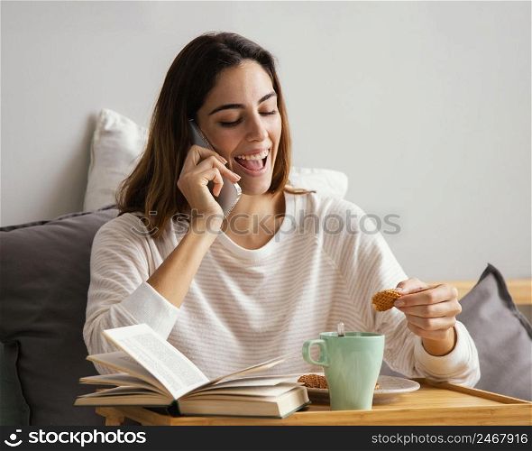 woman talking phone while having breakfast home