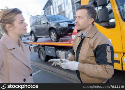 woman talking to broken car assistance