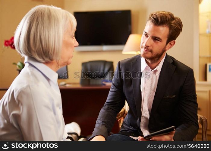 Woman Talking To Male Counsellor Using Digital Tablet