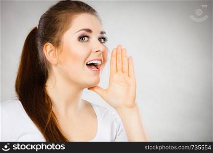 Woman talking to someone gossip and rumors with hand close to lips.. Woman talking gossip with hand close to lips