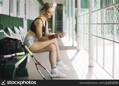 woman tennis player checking her phone