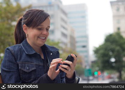 Woman texting with her smart phone outside