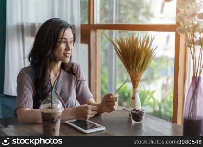 woman thinking and using tablet in the cafe