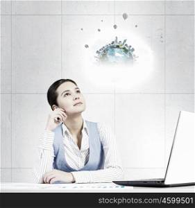 Woman thinking over her project. Young attractive businesswoman sitting at table and thinking something over. Elements of this image are furnished by NASA
