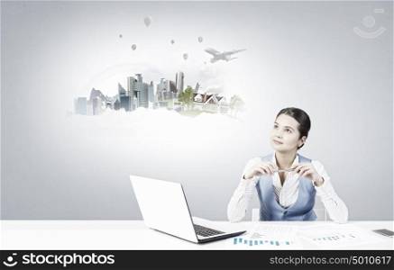 Woman thinking over her project. Young attractive businesswoman sitting at table and thinking something over