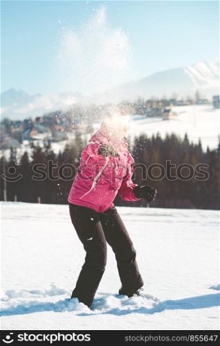 Woman throwing the snow in the air