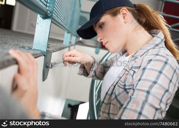 woman tightens screw brackets vertical blind headrails