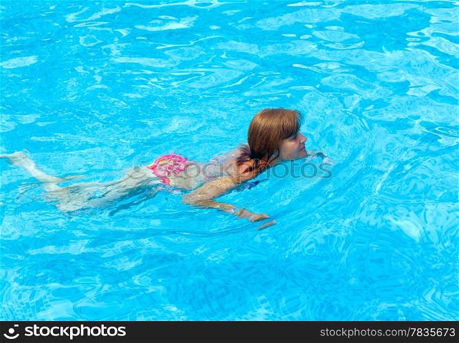 Woman to swim in the summer outdoor pool.