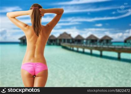 Woman topless on beautiful beach with water bungalows at Maldives. Collage.