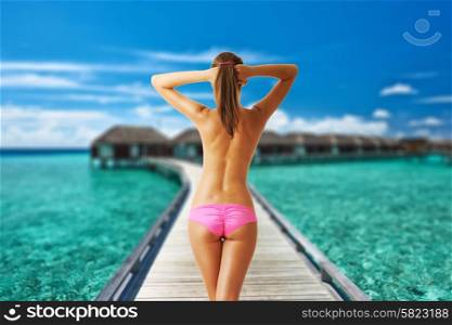 Woman topless on beautiful beach with water bungalows at Maldives. Collage.