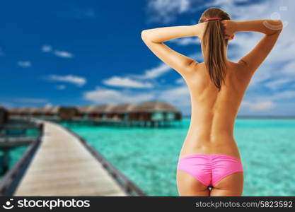 Woman topless on beautiful beach with water bungalows at Maldives. Collage.