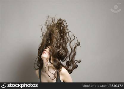 Woman tossing long brown wavy hair