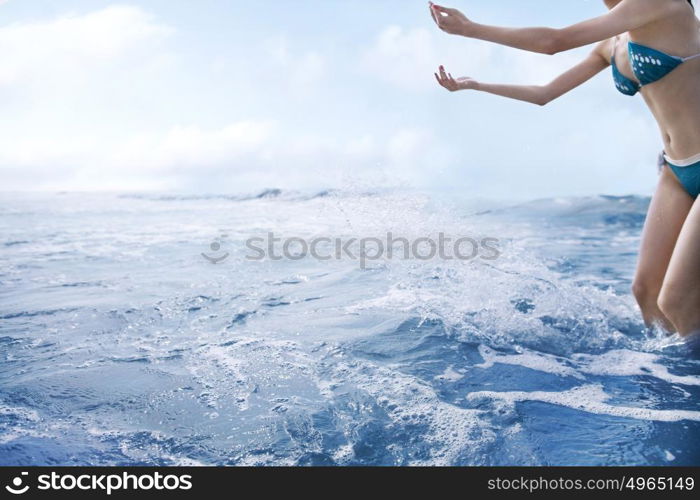 Woman tossing water into air at the beach