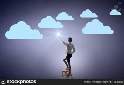 Woman touch cloud. Businesswoman standing on chair and reaching cloud in sky