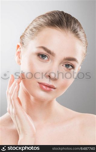 Woman touch own face. Beautiful young woman with clean fresh skin touch own face. Facial treatment. Cosmetology, beauty and spa