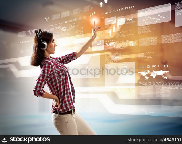 Woman touching virtual screen. Image of young woman with headphones touching virtual screen