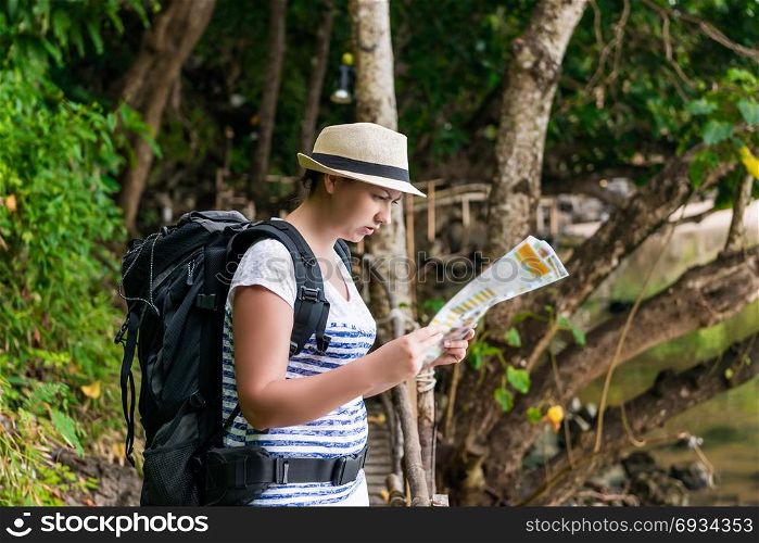 woman tourist in a hat with a backpack on a hike in Asia