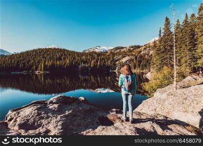 Woman tourist near Bear Lake at autumn in Rocky Mountain National Park. Colorado, USA.