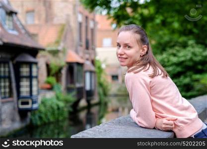 Woman tourist near Bruges (Brugge) water canal, Flanders, Belgium