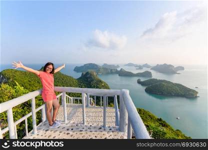 Woman tourist on peak viewpoint of island. Woman tourist on the balcony is peak view point of Ko Wua Ta Lap island and beautiful nature landscape during sunrise over the sea in Mu Ko Ang Thong National Park, Surat Thani, Thailand