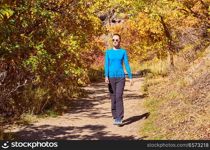 Woman tourist walking on trail in aspen grove at autumn in Rocky Mountain National Park. Colorado, USA.