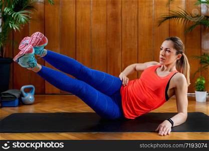 Woman training abdominals on High-intensity interval training at home