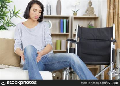 woman transferring herself from the wheelchair to the sofa