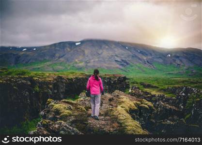 Woman traveler and explorer travels in the Icelandic landscape hiking across Iceland to discover unique nature in summer.