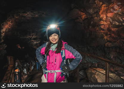 Woman traveler explore lava tunnel in Iceland. Raufarholshellir is a beautiful hidden world of cave. It is one of the longest and best-known lava tubes in Iceland, Europe for incredible adventure.