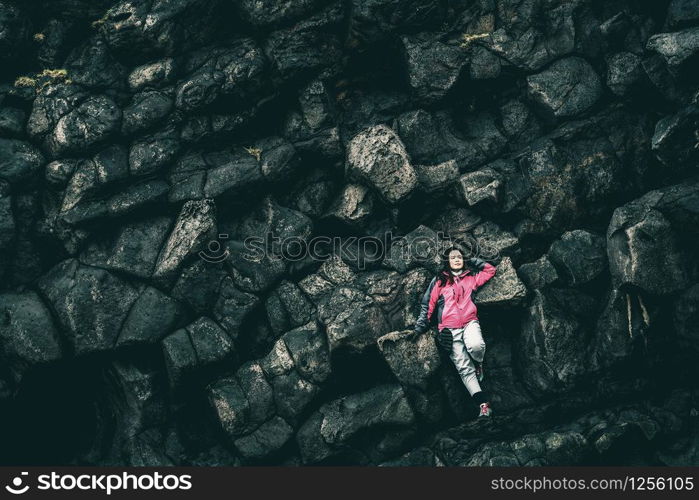 Woman traveler on rocky ridge in Hellnar, Iceland. Tourism and explore concept.