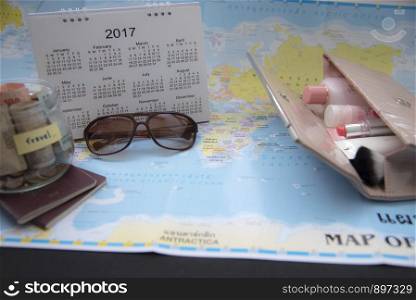 Woman Traveler Planning with her stuff. Saving money and show a calendar. Travel with cosmetics set.