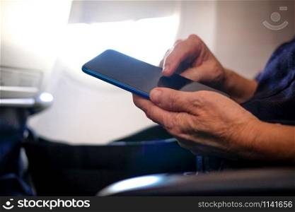 woman traveler using smartphone in airplane. passenger holding mobile phone in aircraft. travel and connection