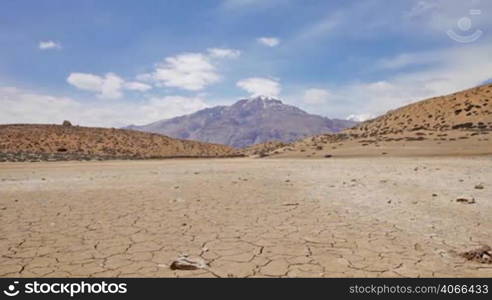 Woman traveler walks on a dry mountain lake. India.