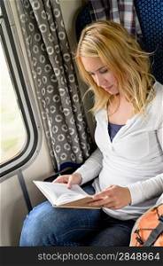 Woman traveling by train and reading book commuter journey sitting