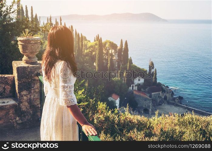 Woman traveller enjoys scenic view of Adriatic coast in Trsteno, Dalmatia, Croatia. Tourist attraction near Dubrovnik old town.