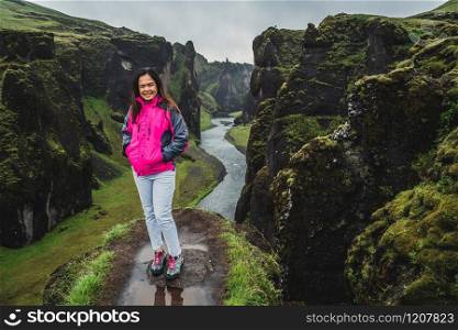 Woman traveller hike Fjadrargljufur in Iceland. Top tourism destination. Fjadrargljufur Canyon is a massive canyon about 100 meters deep and about 2 kilometers long, located in South East of Iceland.