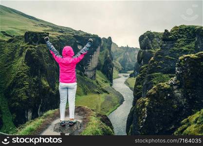 Woman traveller hike Fjadrargljufur in Iceland. Top tourism destination. Fjadrargljufur Canyon is a massive canyon about 100 meters deep and about 2 kilometers long, located in South East of Iceland.