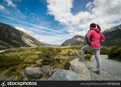 Woman traveller traveling in wilderness landscape of Mt Cook National Park. Mt Cook, the highest mountain in New Zealand,is known for scenic landscape, outdoor travel inspiration, mountain trekking.