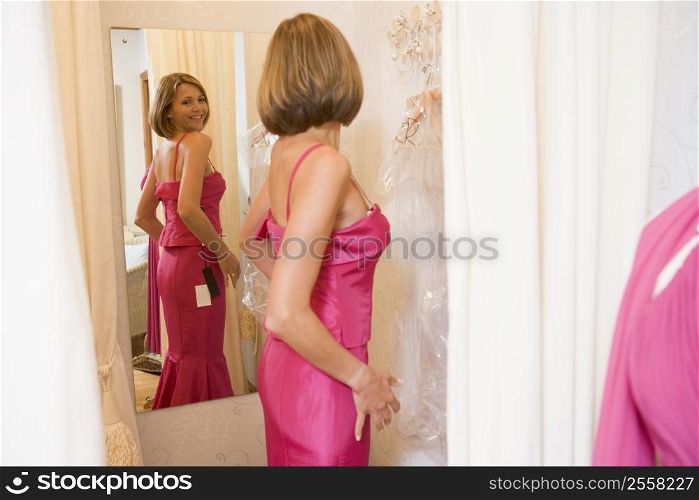 Woman trying on dresses and smiling
