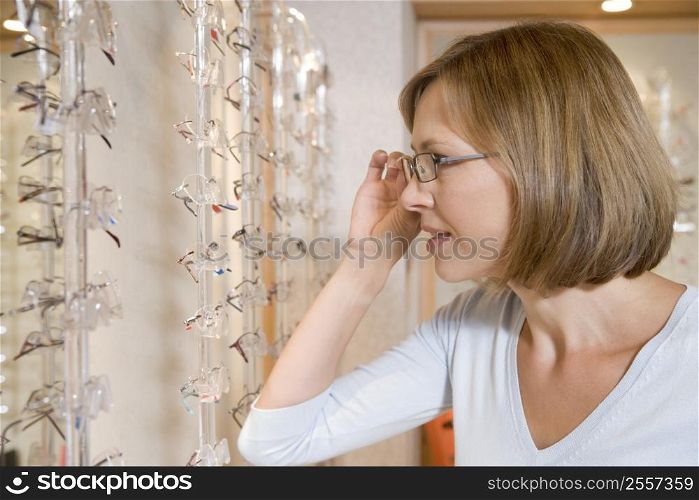 Woman trying on eyeglasses at optometrists
