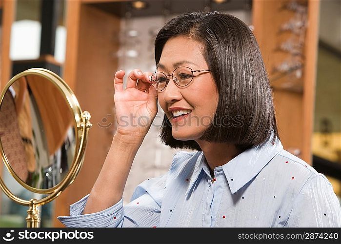 Woman trying on eyeglasses in store