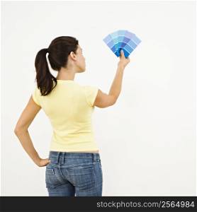 Woman trying to choose color for interior wall.