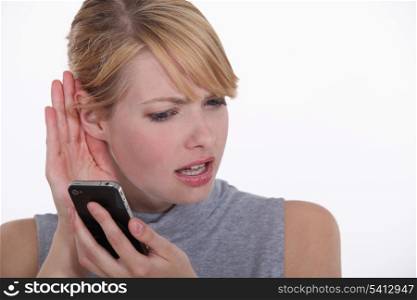 woman trying to hear a person on her cell phone