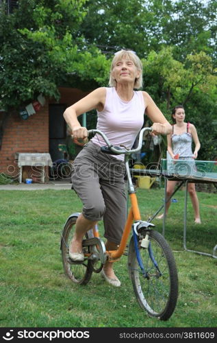 Woman trying to ride old bicycle