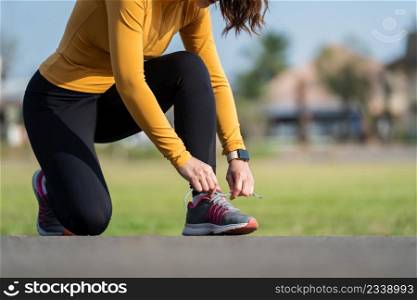 woman tying her running shoes in the park