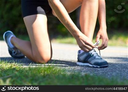 Woman tying her shoes before running