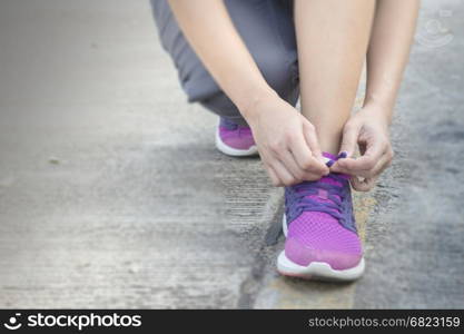 Woman tying her shoes preparing for a jog, stock photo