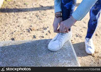 Woman tying the shoelaces on running track on a step